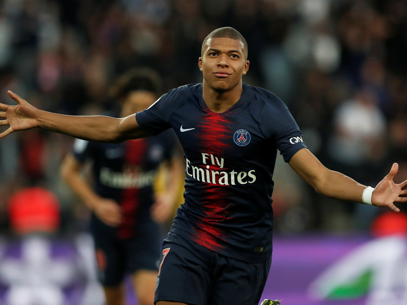 Французский футболист Килиан Мбаппе бежит по полю