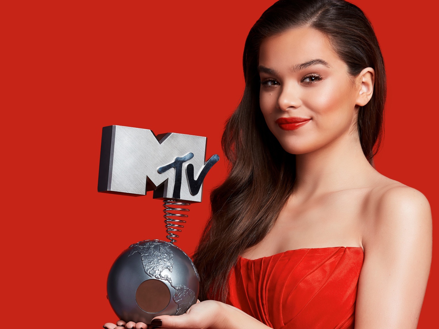 Хейли Стейнфилд с премией MTV на красном фоне