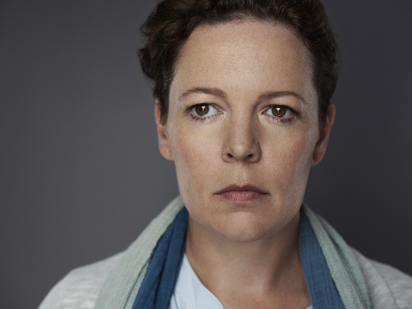 Грустная актриса Оливия Колман на сером фоне