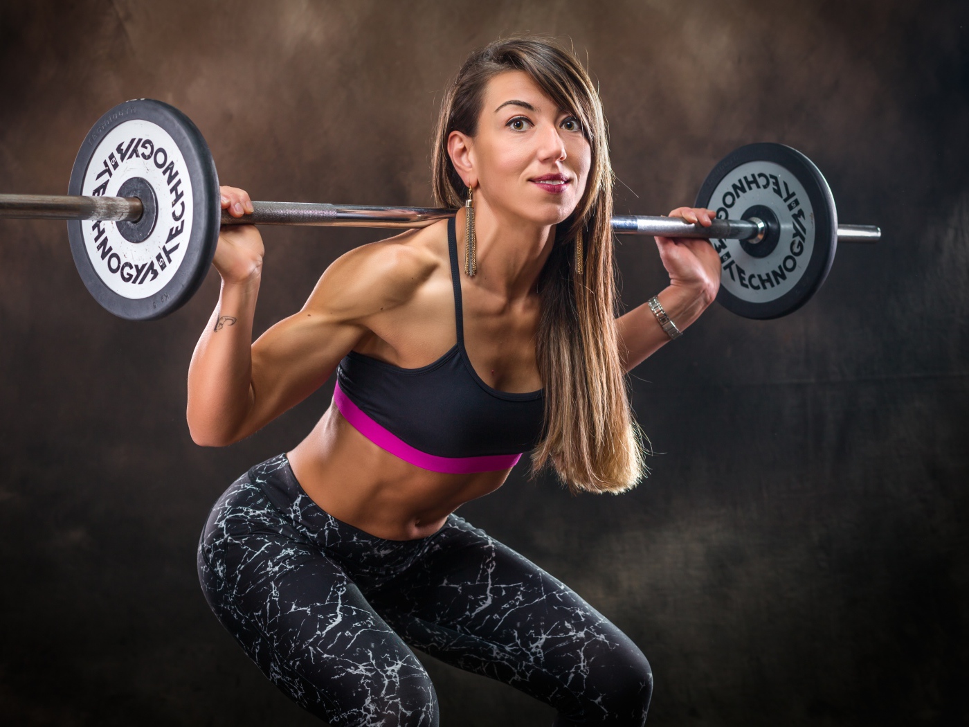 Спортивная накаченная девушка со штангой 