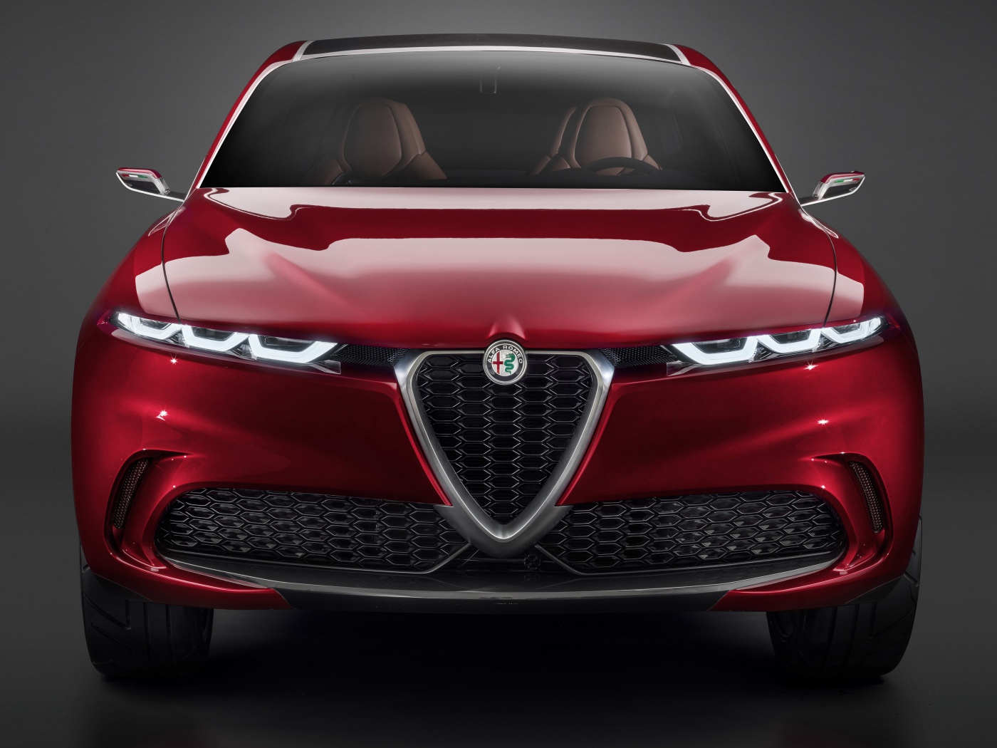 Красный автомобиль Alfa Romeo Tonale Concept,  2019 года вид спереди на сером фоне