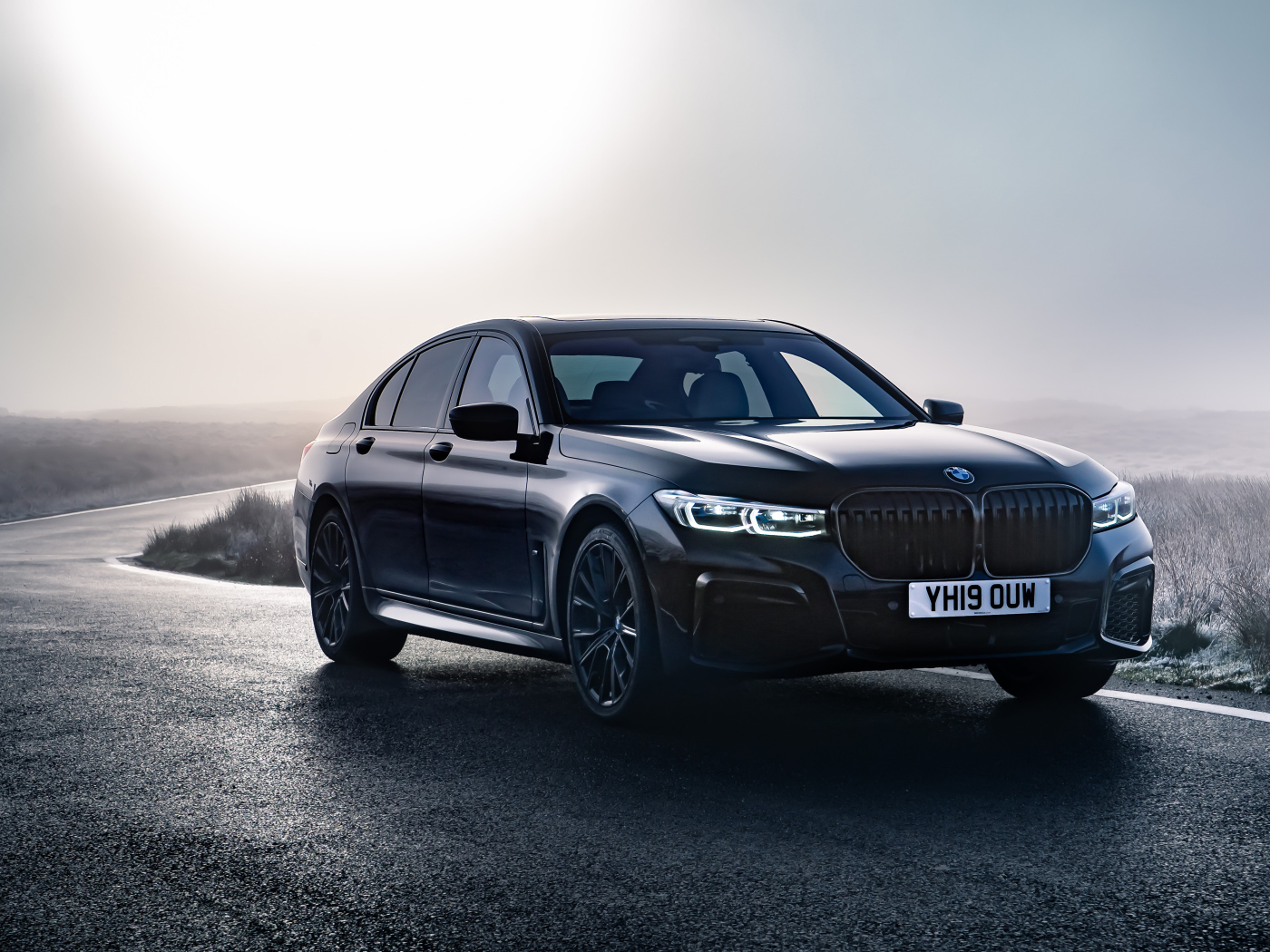Черный автомобиль BMW 750i xDrive M Sport 2019 года на дороге 