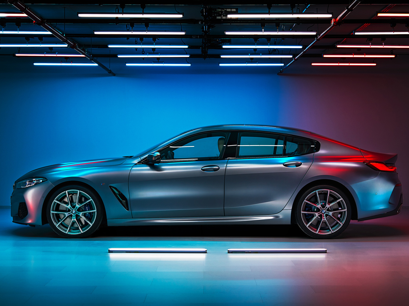 Серебристый автомобиль BMW M850i,  2019 года вид сбоку