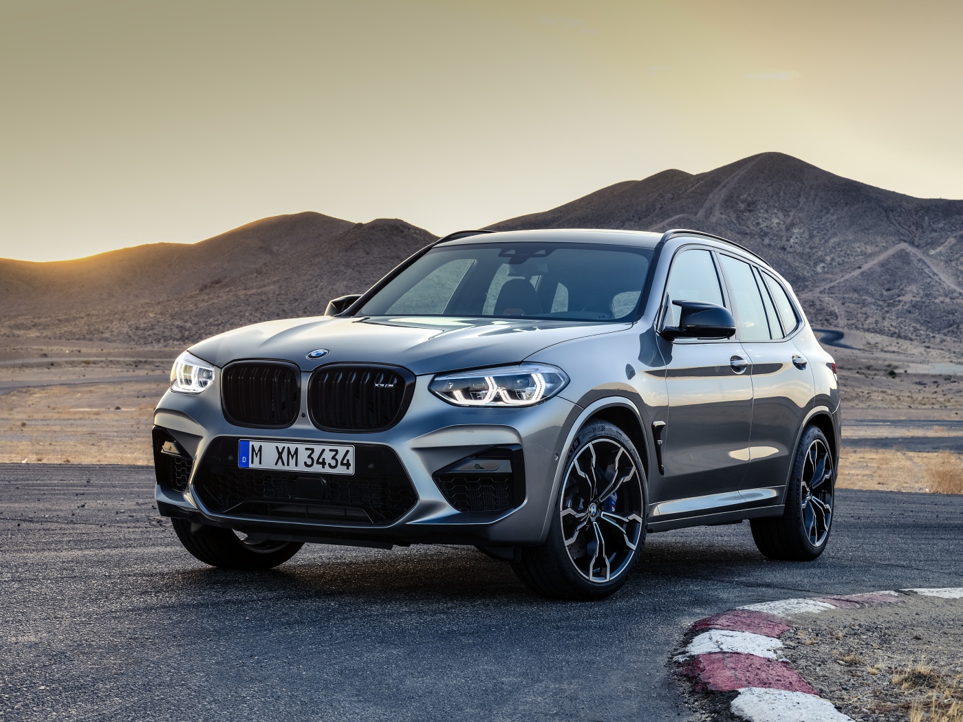 Серебристый автомобиль BMW X3  на асфальте