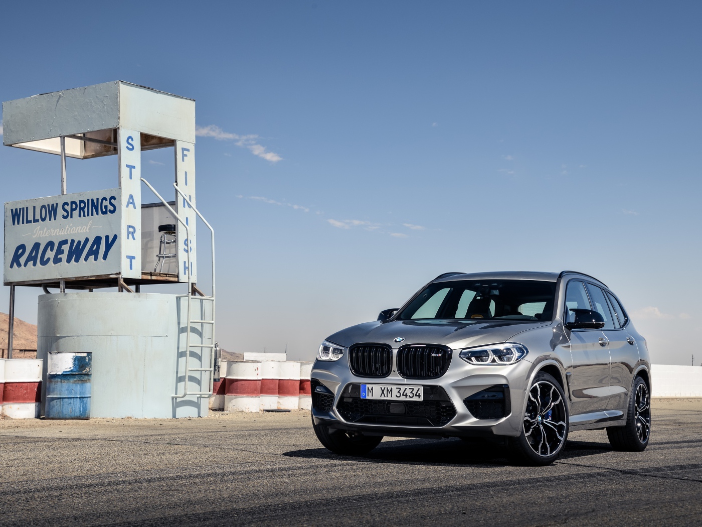Серебристый автомобиль BMW X3 на асфальте