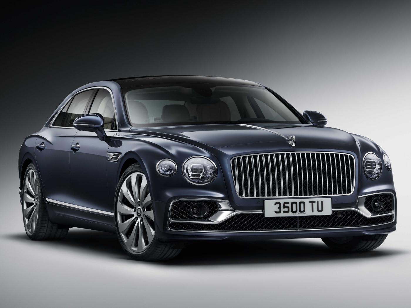 Дорогой автомобиль Bentley Flying Spur 2019 года на сером фоне