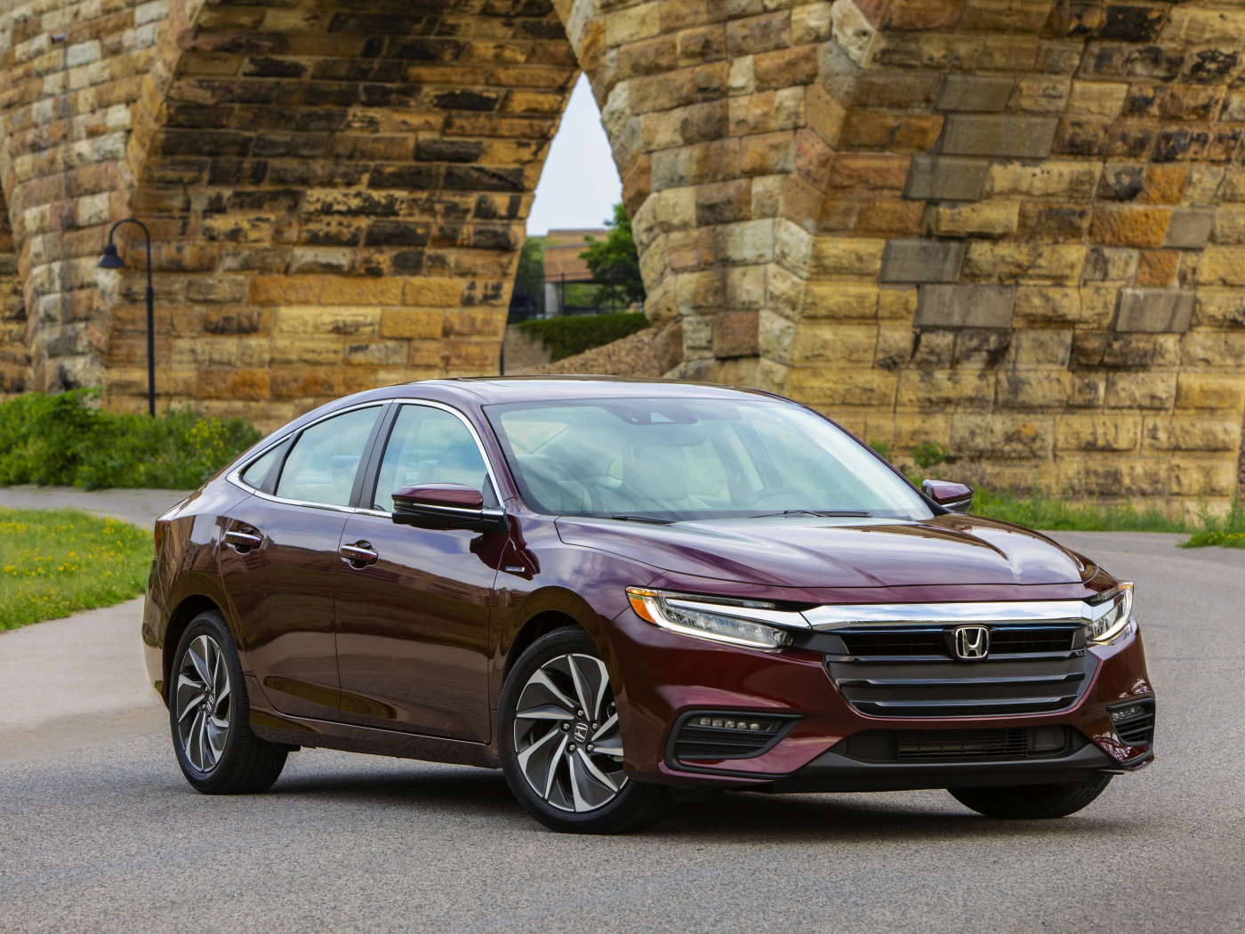 Бордовый автомобиль Honda Insight у моста