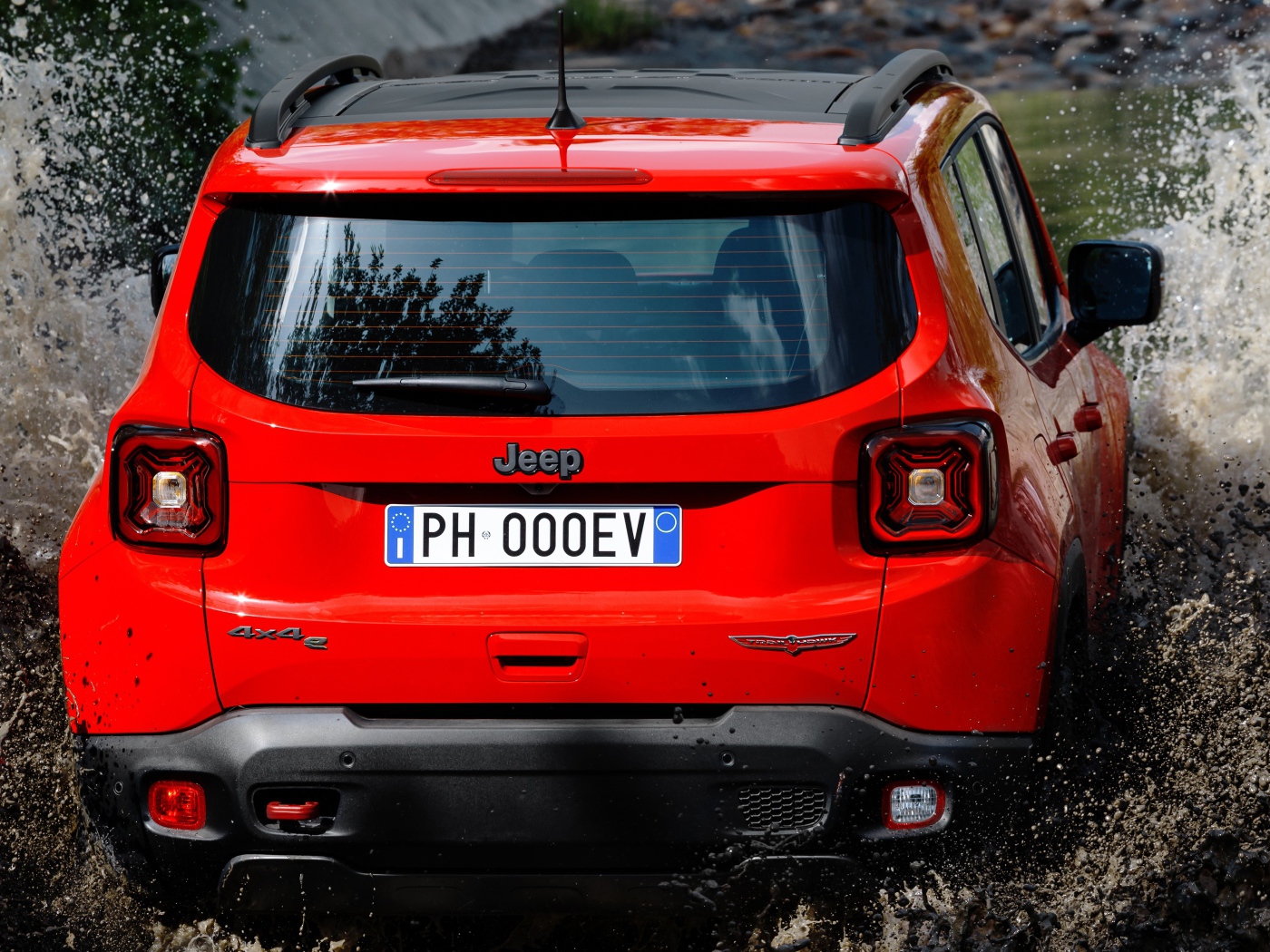 Красный Jeep Renegade Trailhawk Plug-In Hybrid, 2019 года едет по воде вид сзади