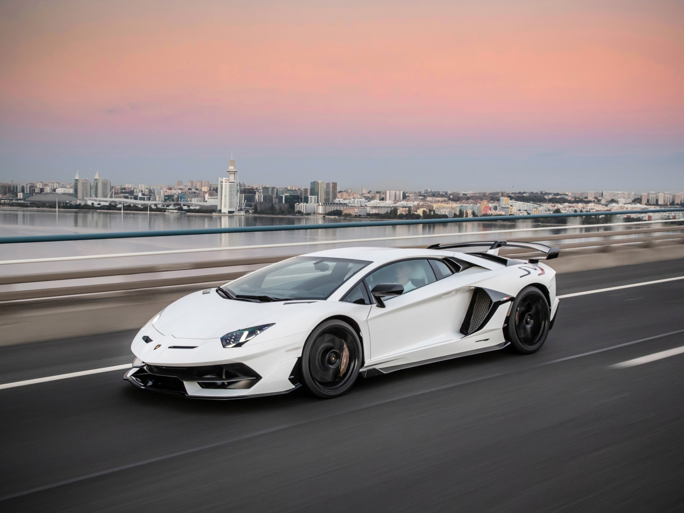 Белый автомобиль Lamborghini Aventador на трассе