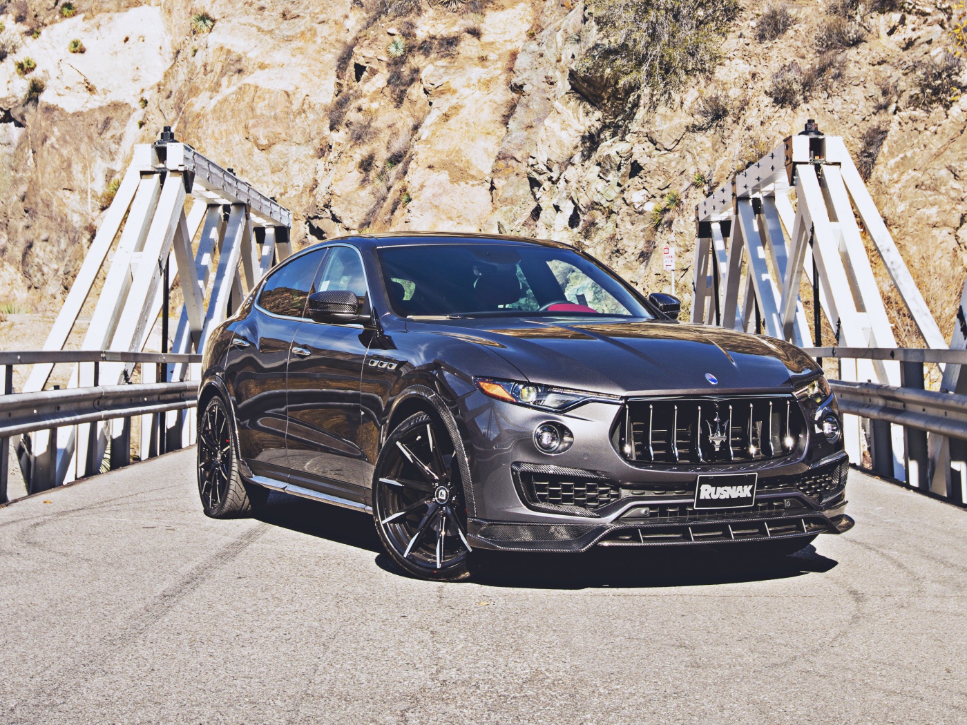 Внедорожник Maserati Levante на мосту на фоне гор