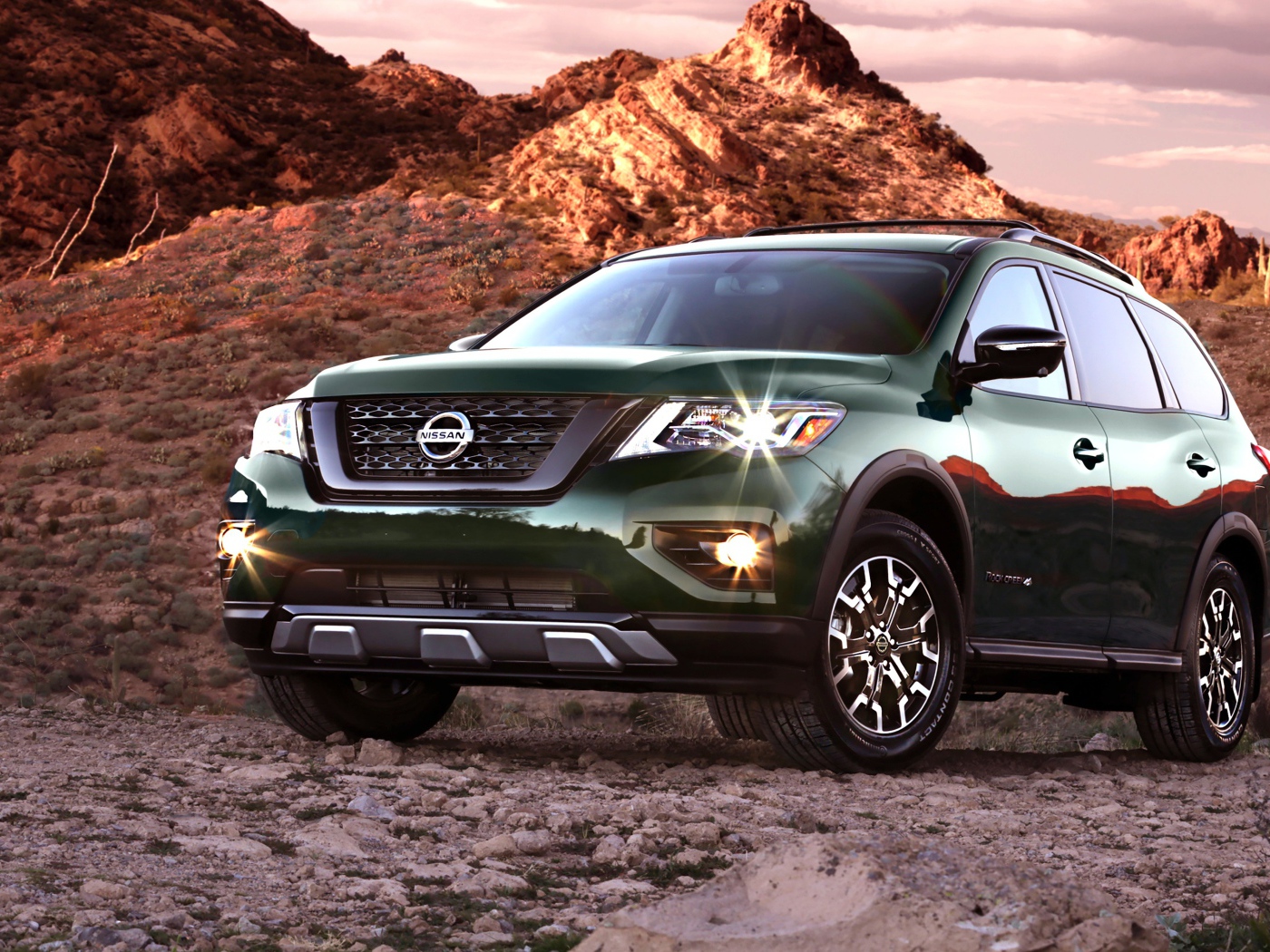 Зеленый автомобиль Nissan Pathfinder в горах 