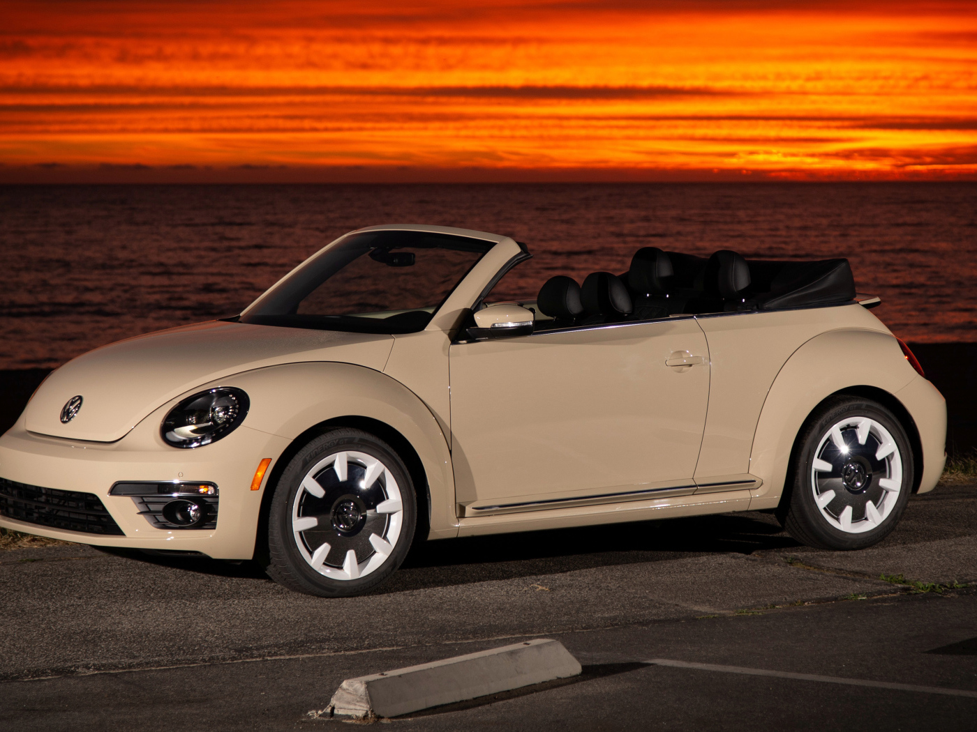Белый кабриолет Volkswagen Beetle SEL на фоне океана на закате