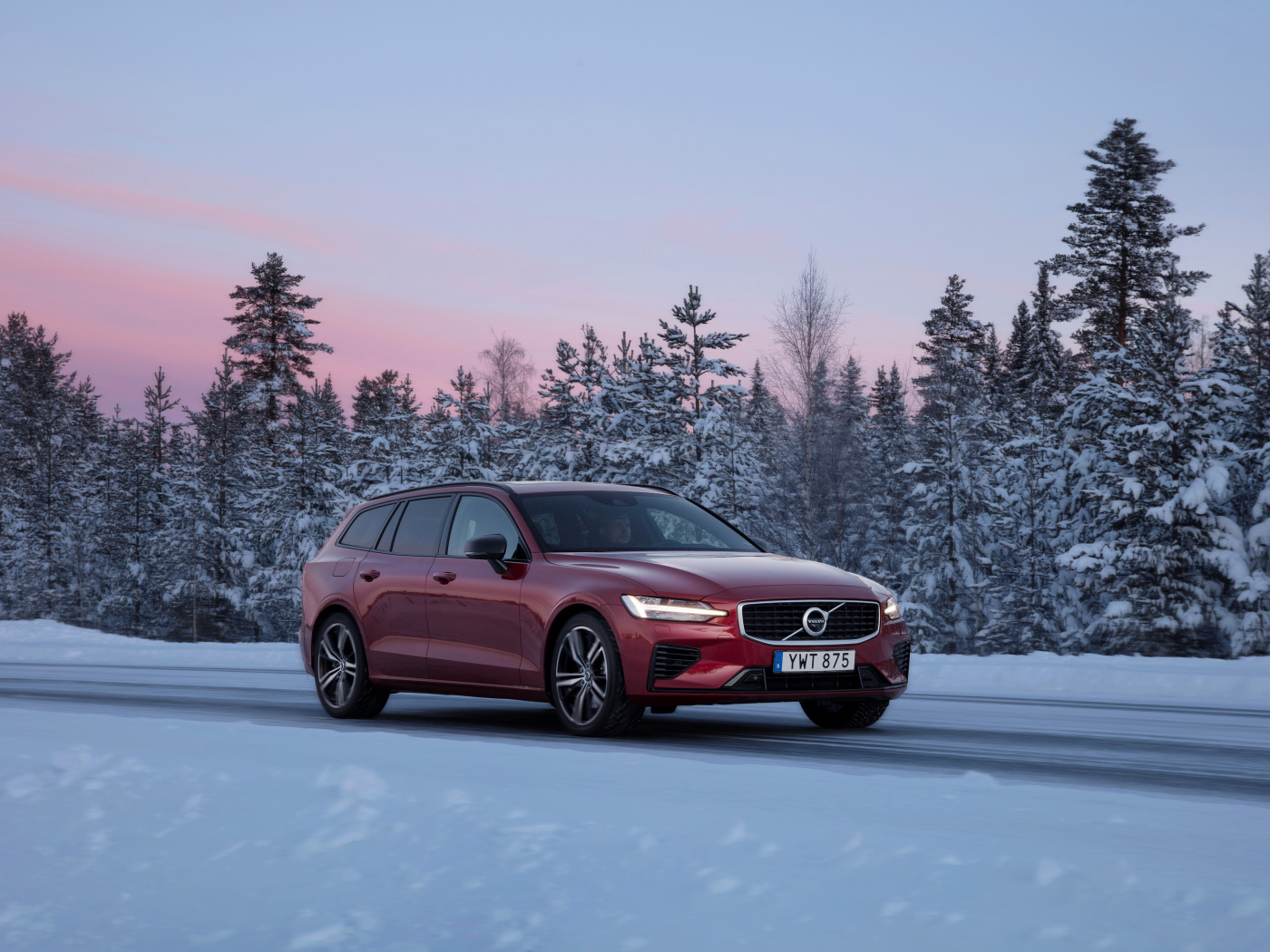 Красный автомобиль Volvo V60 на зимней дороге