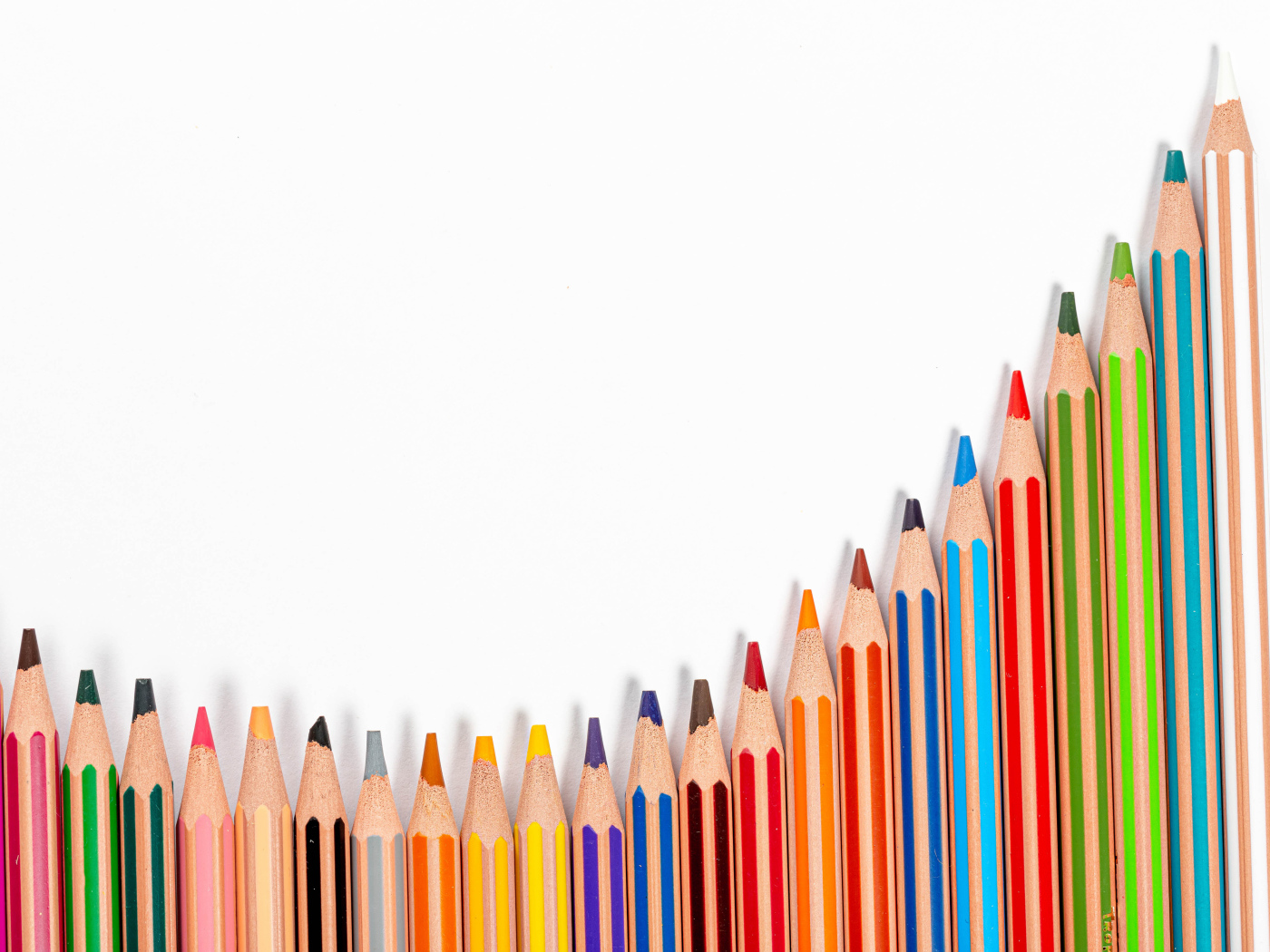 Много разноцветных карандашей на белом фоне