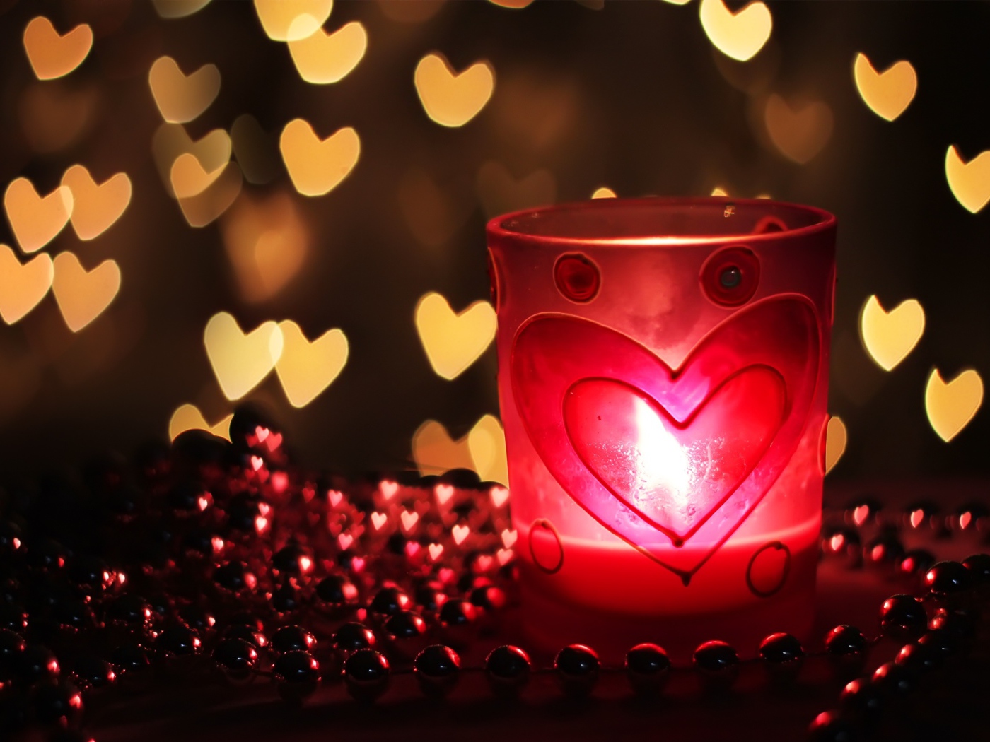 Зажженная свеча на столе с бусами 