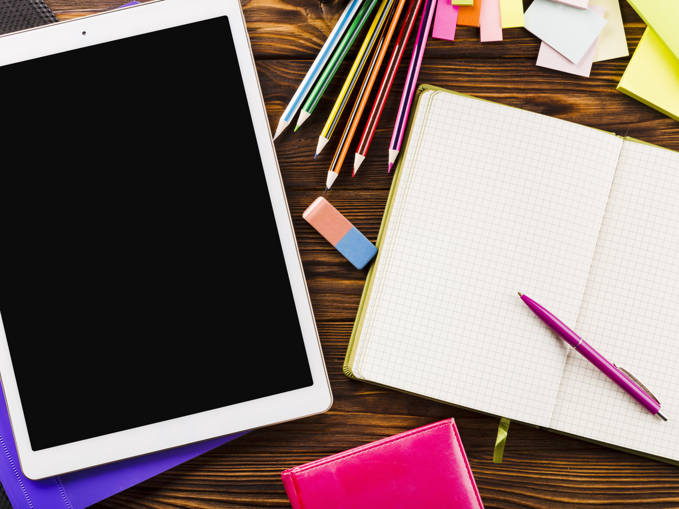 Планшет на столе с блокнотом и карандашами