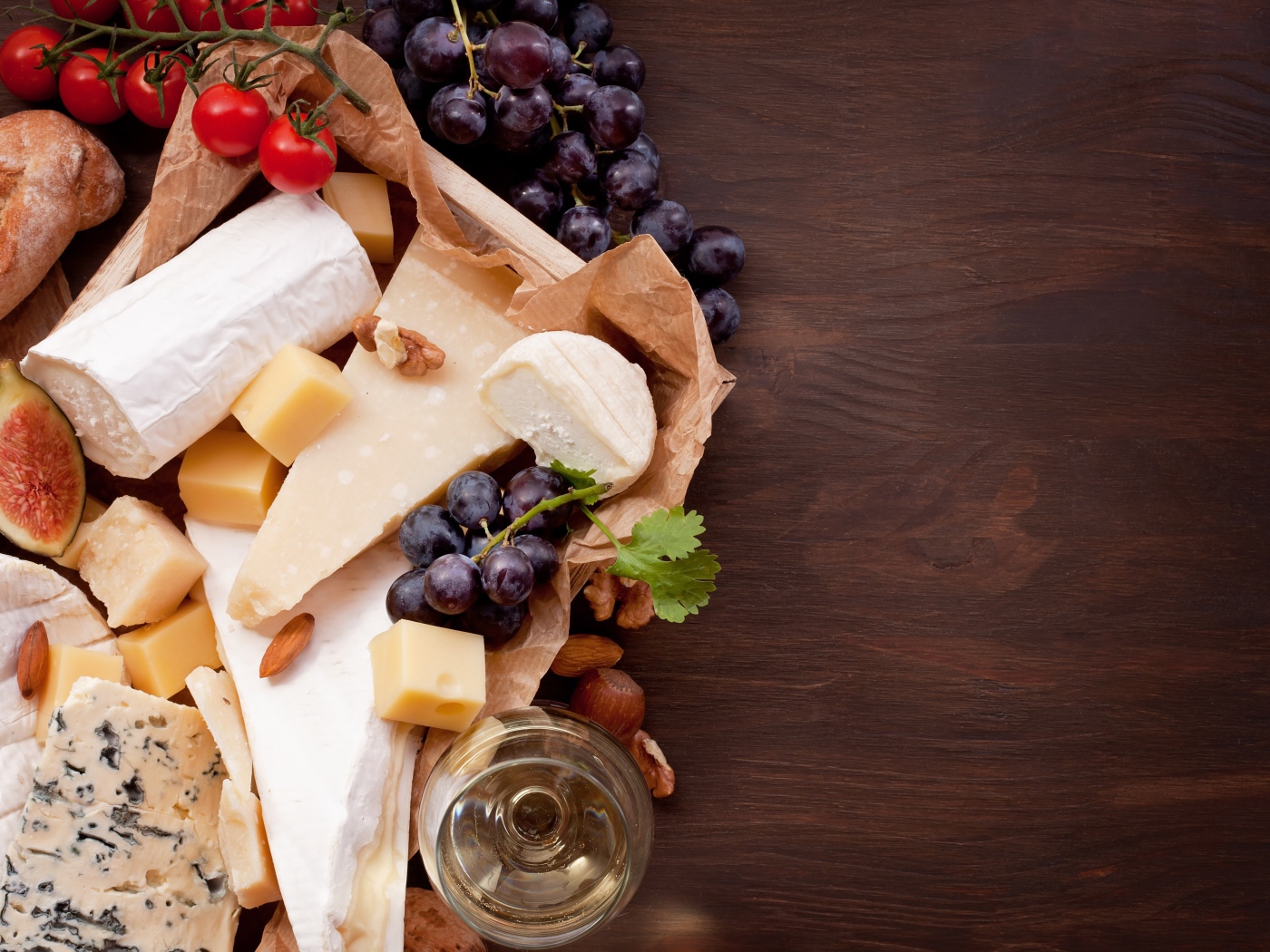 Сыр на столе с виноградом, инжиром и помидорами