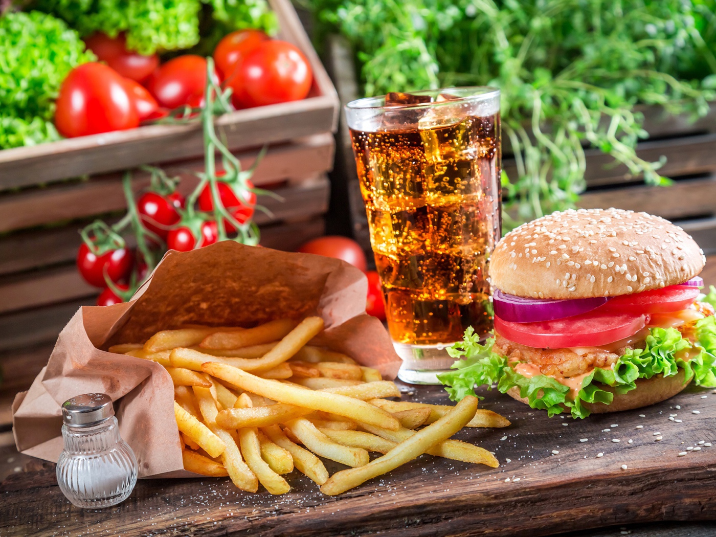 Картофель фри, гамбургер, кола и помидоры на столе