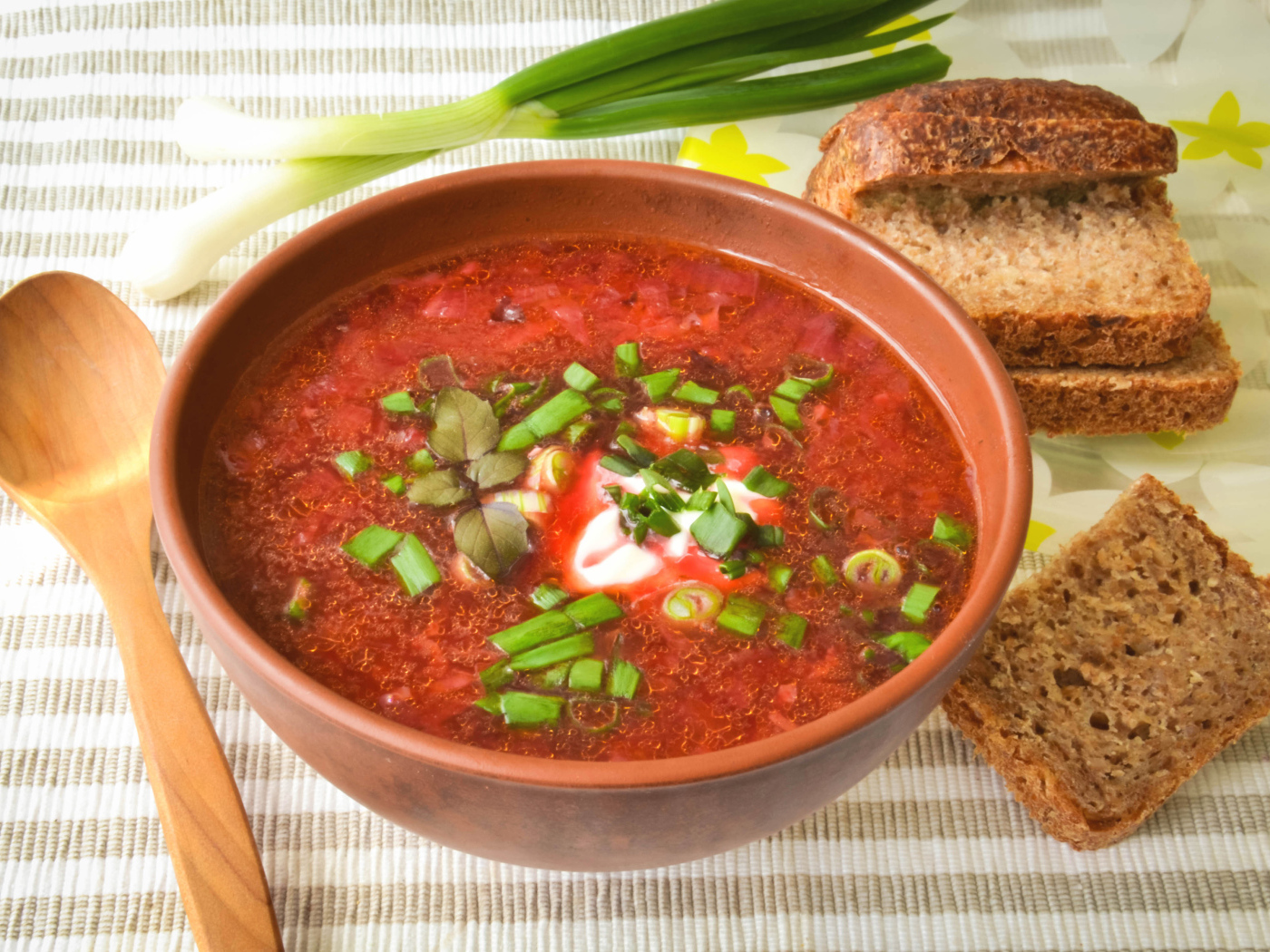 Красный борщ с луком на столе с хлебом 