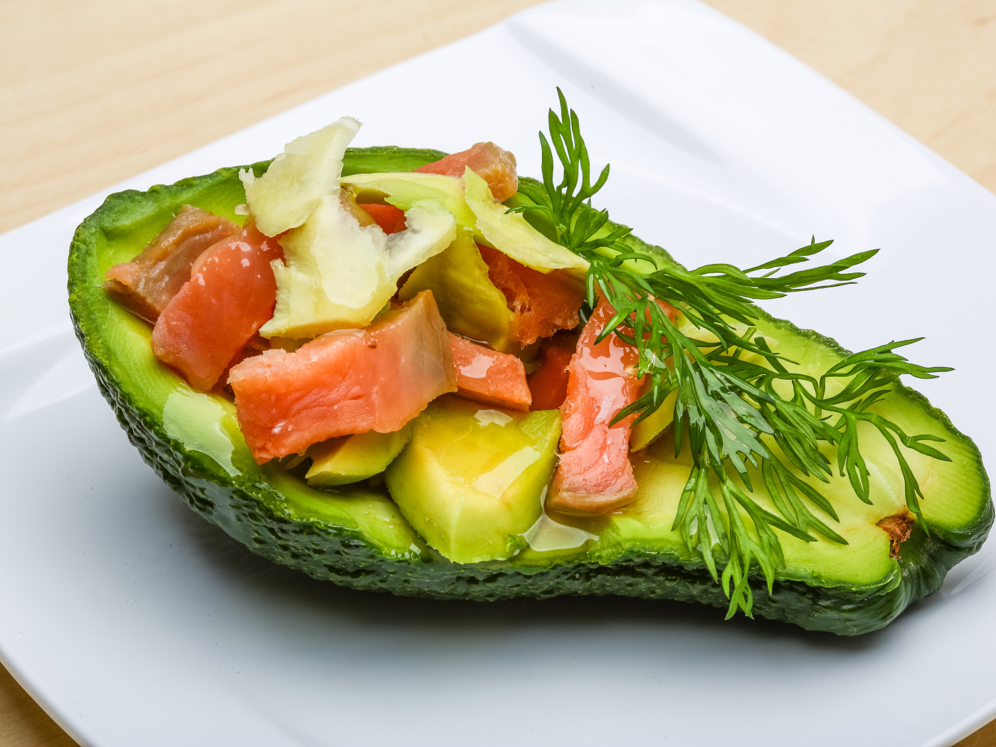 Салат с рыбой и веточкой укропа в авокадо