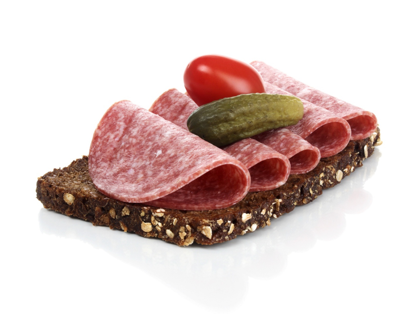 Бутерброд с черным хлебом, колбасой, соленым огурцом и помидором на белом фоне