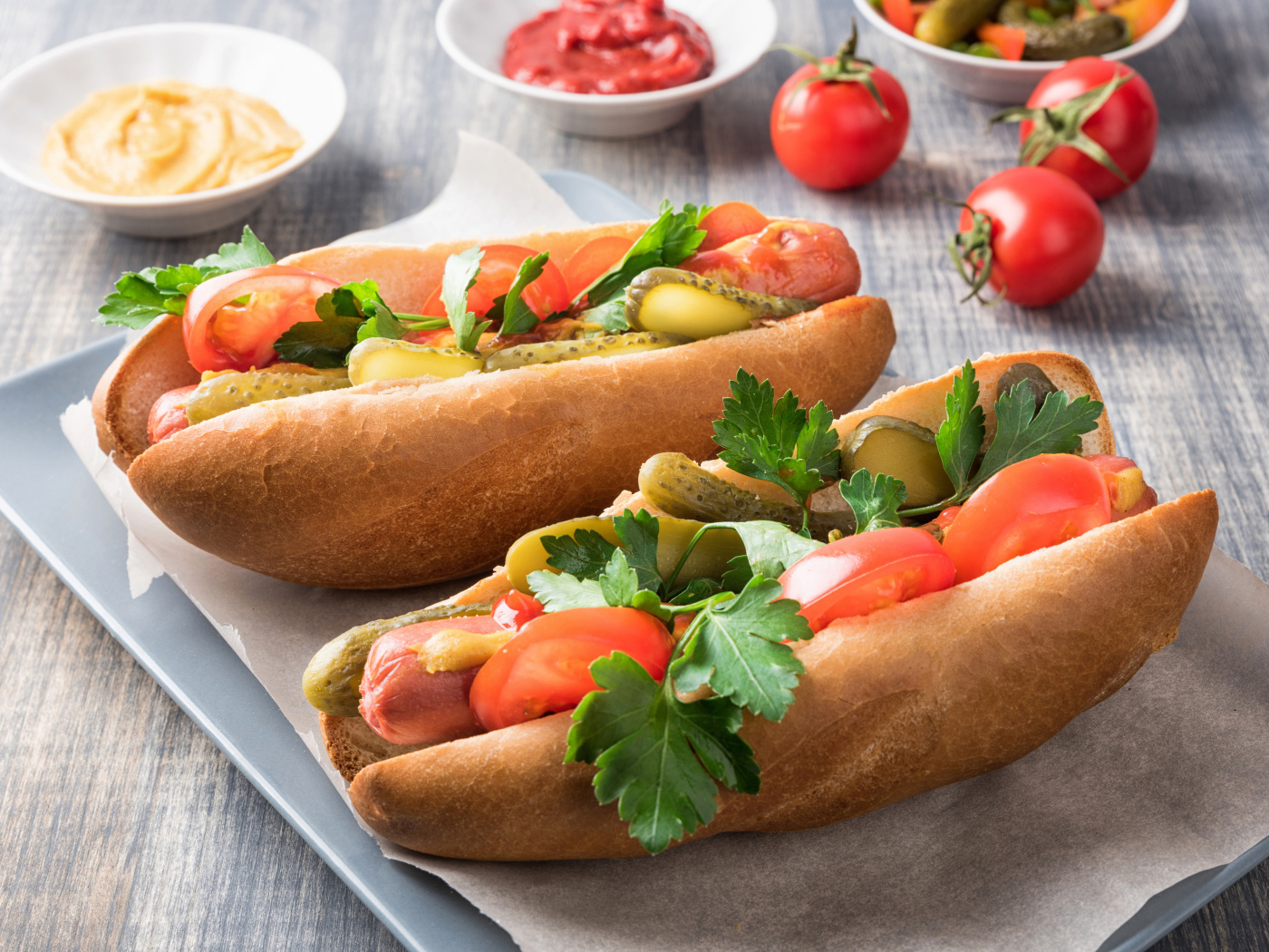 Два хотдога с сосиской, огурцами и помидорами