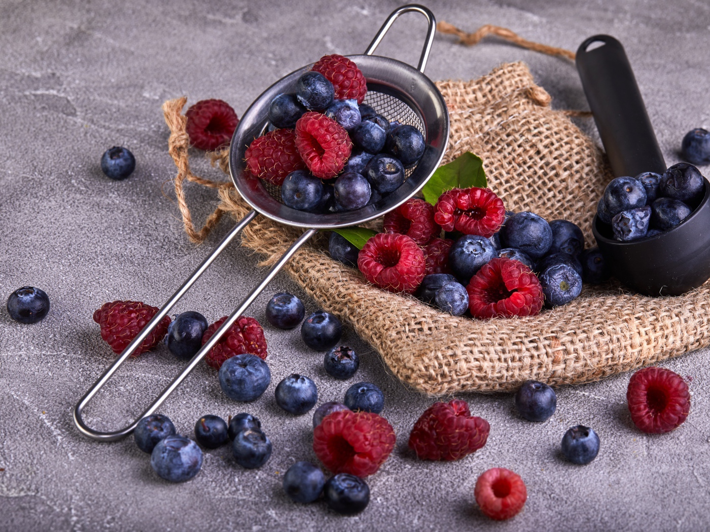 Ягоды черники и малины на столе с ситом