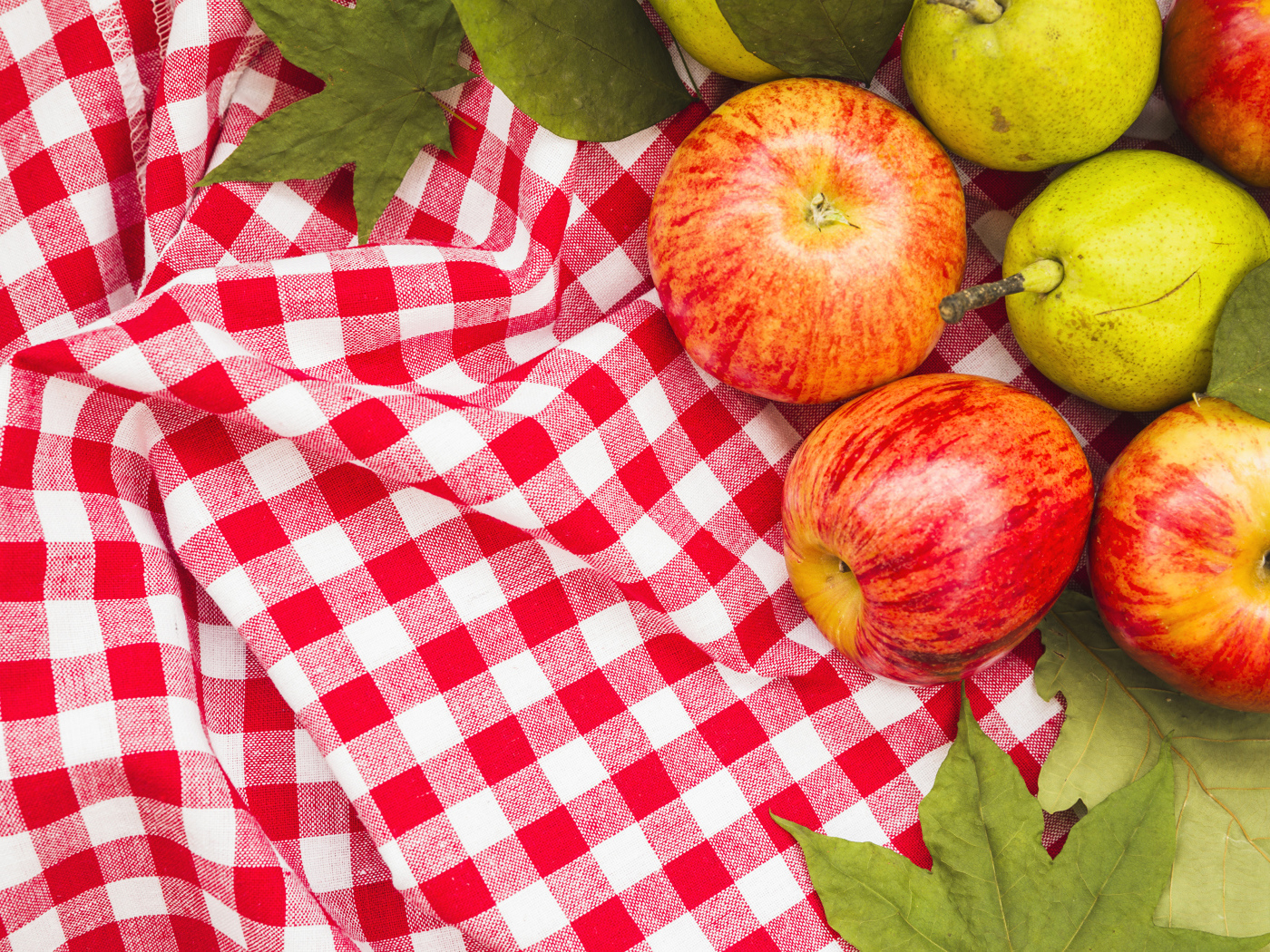 Красные яблоки с грушами на клетчатом покрывале