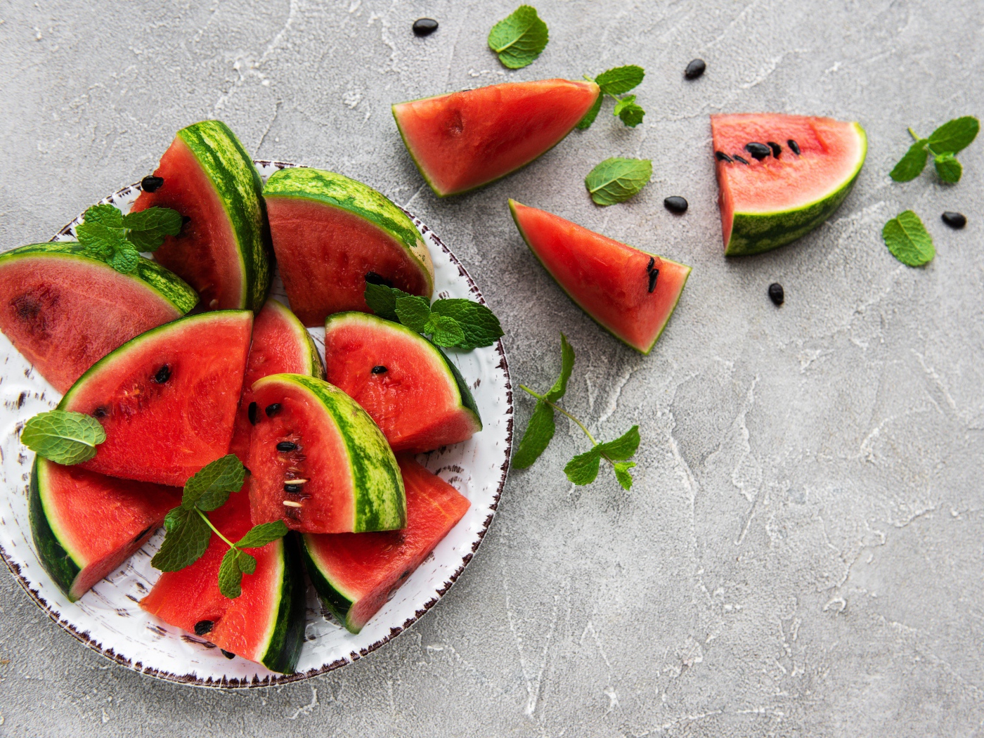 Полосатый арбуз нарезан кусочками на тарелке