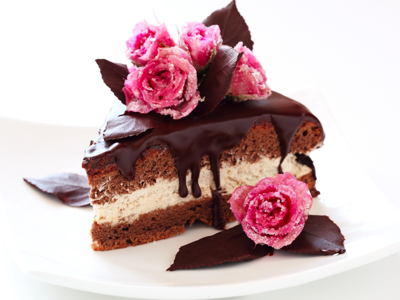 Кусок торта с шоколадом на белом фоне с сахарными розами