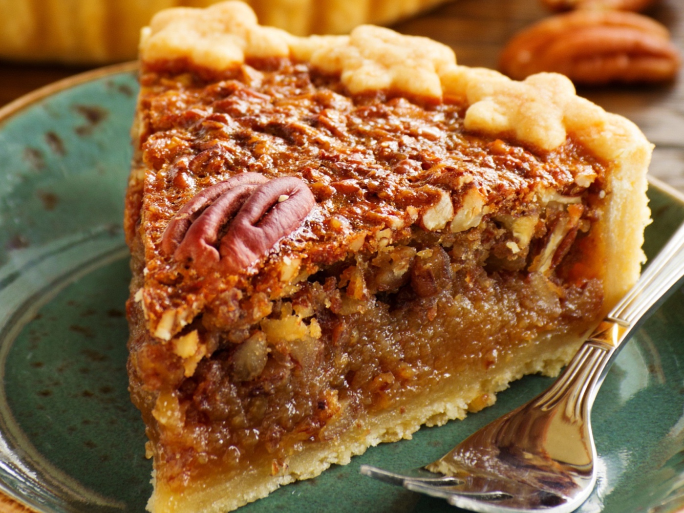 Кусок пирога с орехами на тарелке с вилкой