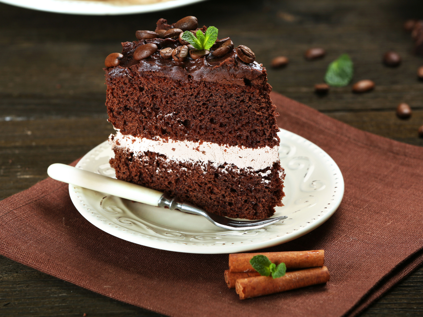 Кусок шоколадного торта с кремом и зернами кофе