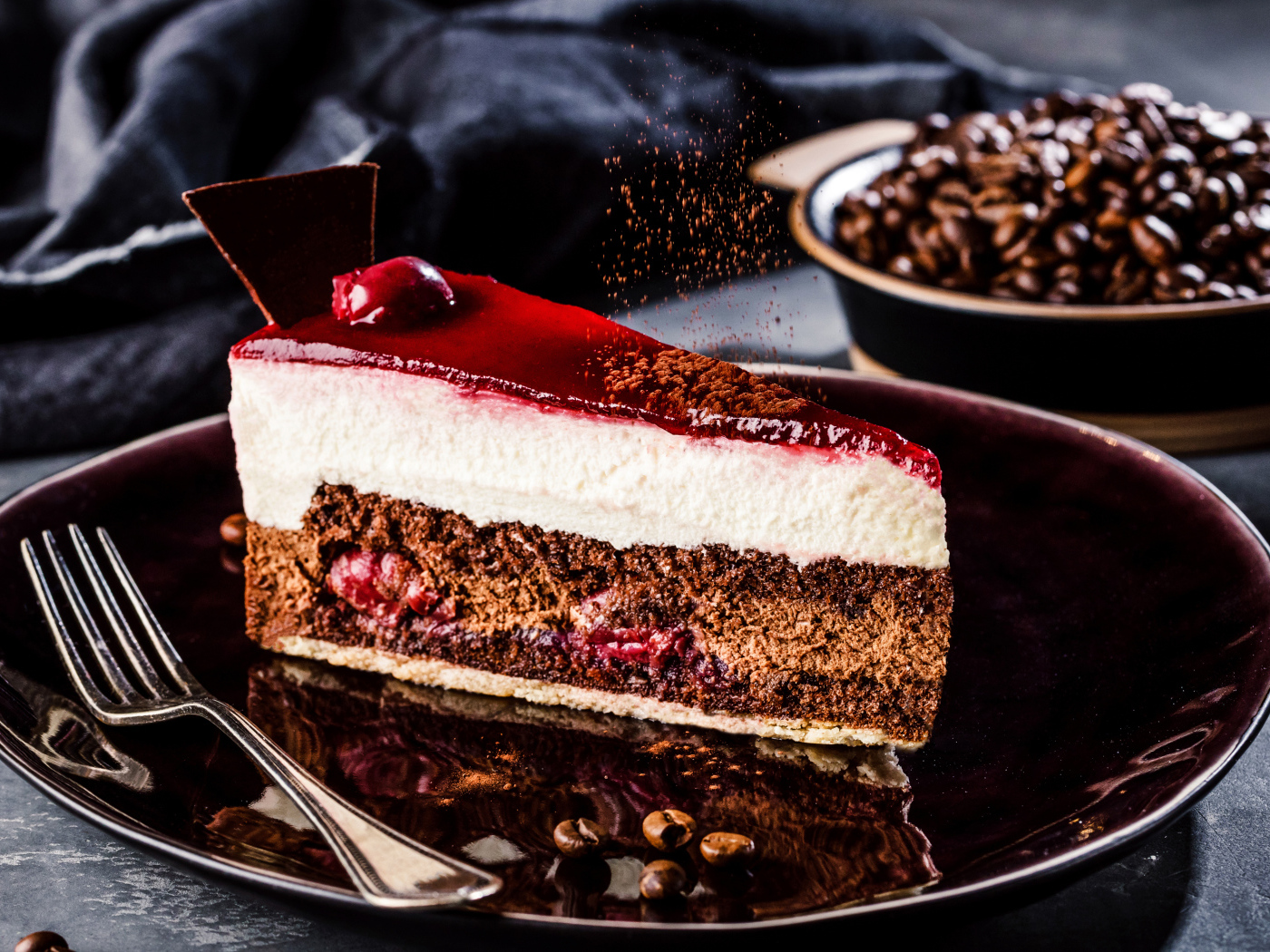 Аппетитный торт с суфле и вишнями на столе с кофейными зернами