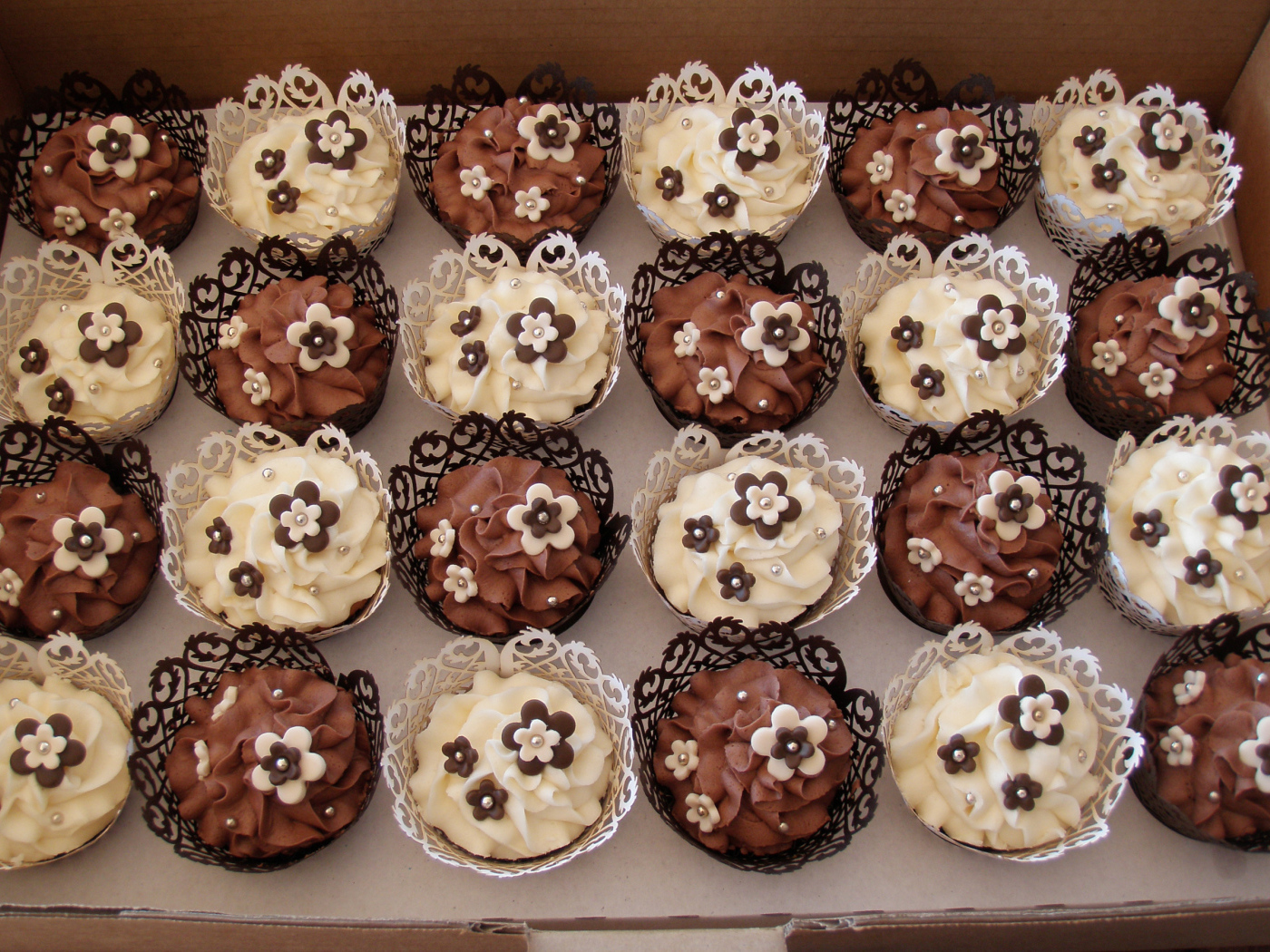 Красивые кексы с кремом и сахарными цветами в ящике