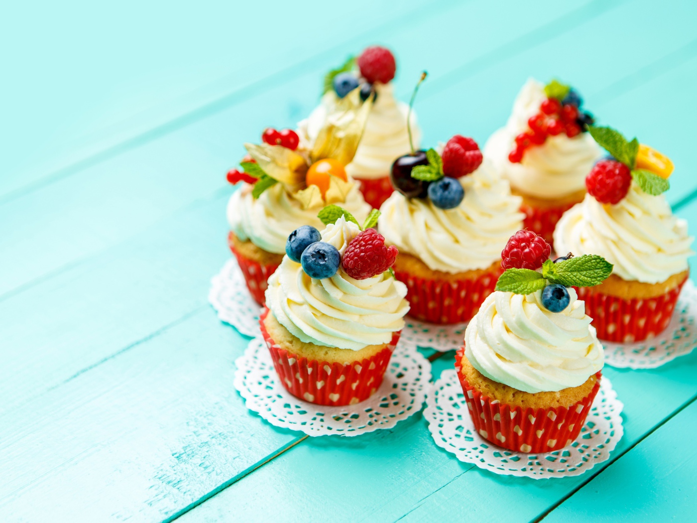 Кексы со взбитыми сливками украшены ягодами