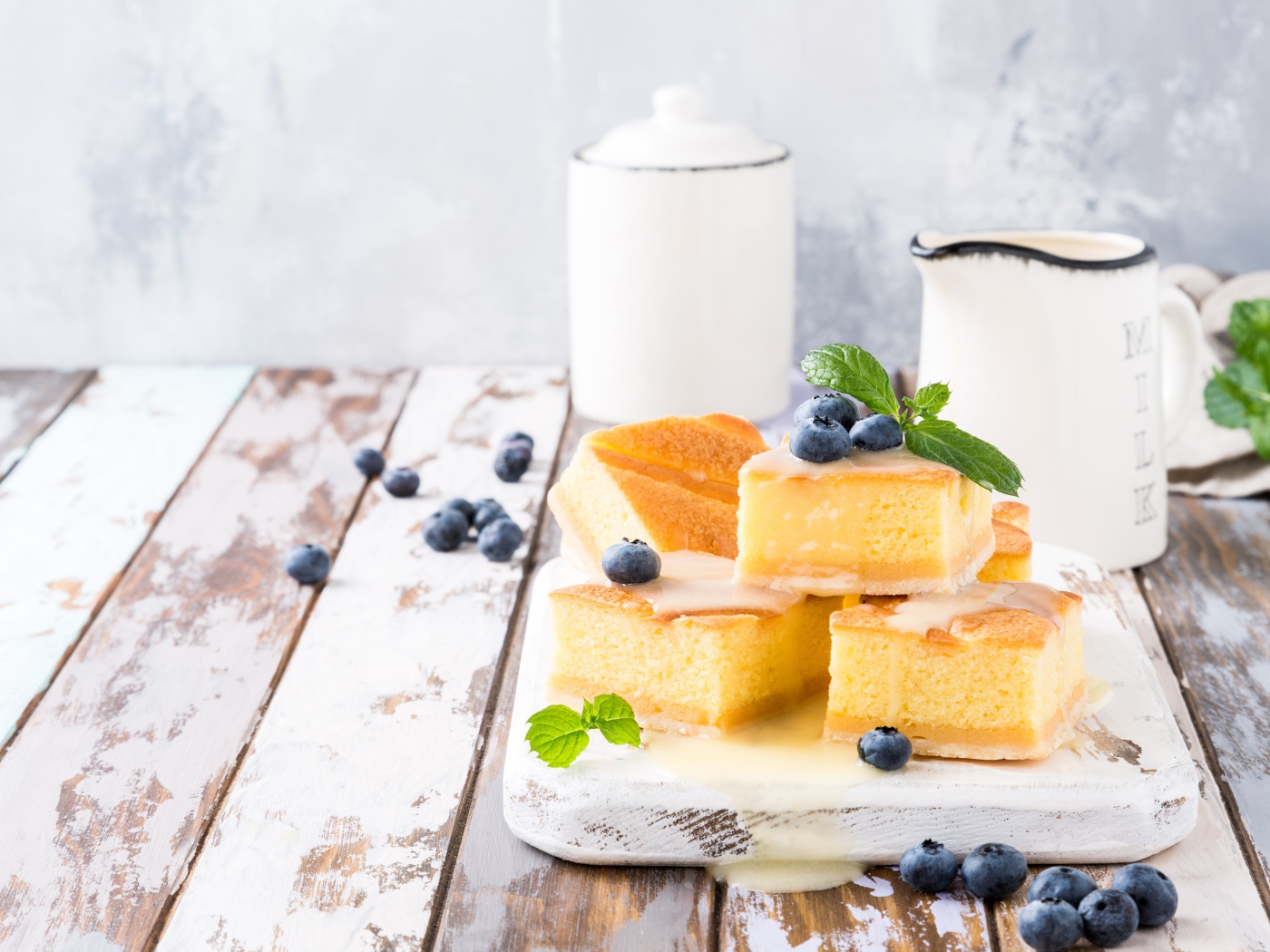 Кусочки бисквитного пирожного на столе с ягодами черники