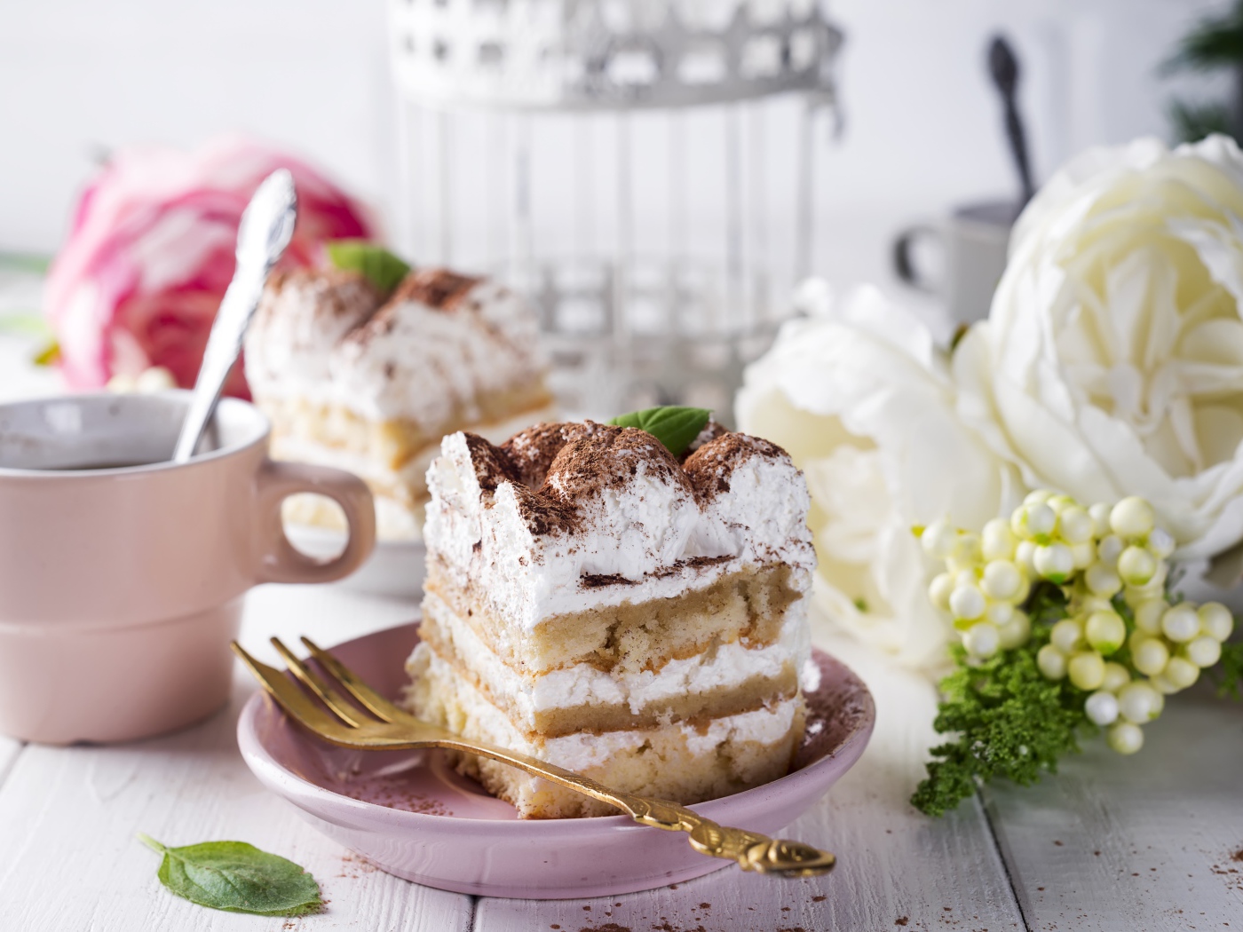 Пирожное на столе с кофе и цветами 