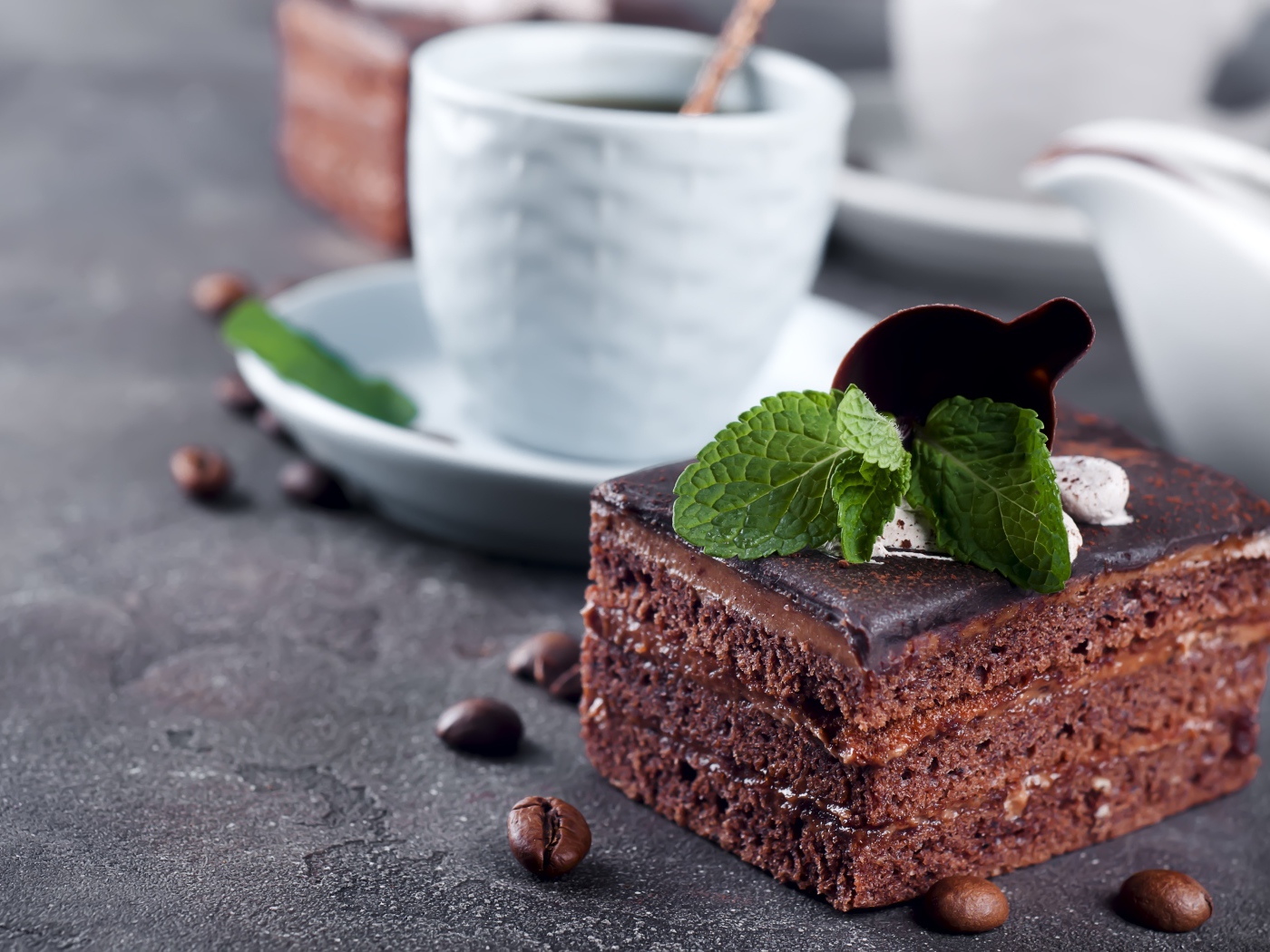 Шоколадное пирожное на столе с чашкой кофе