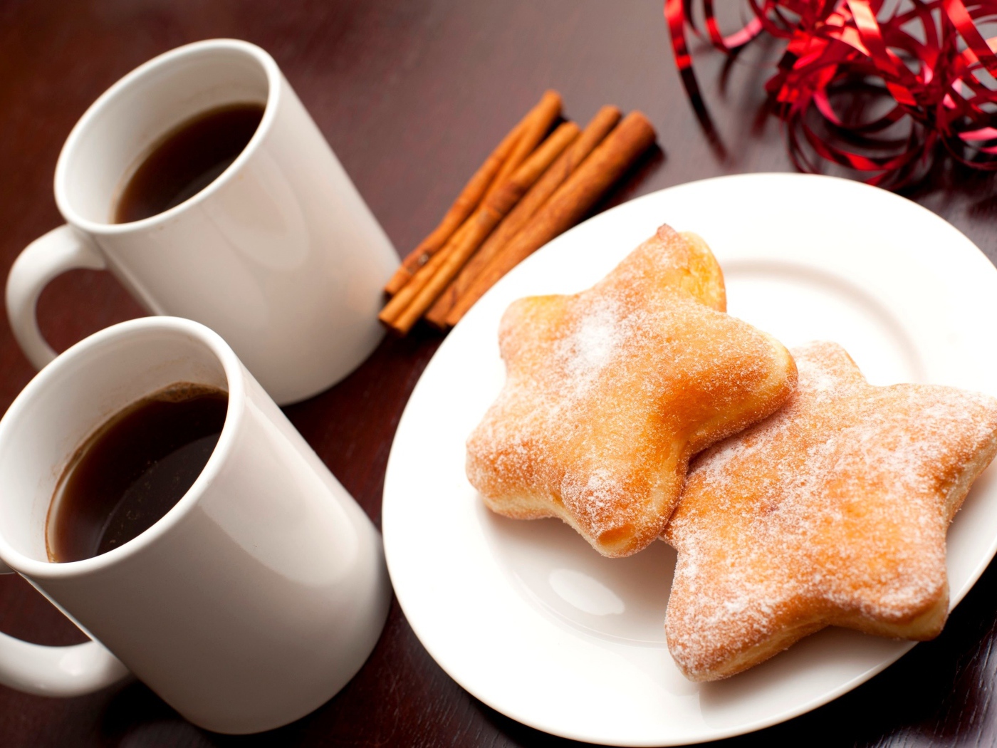 Пончики на столе с кофе и палочками корицы