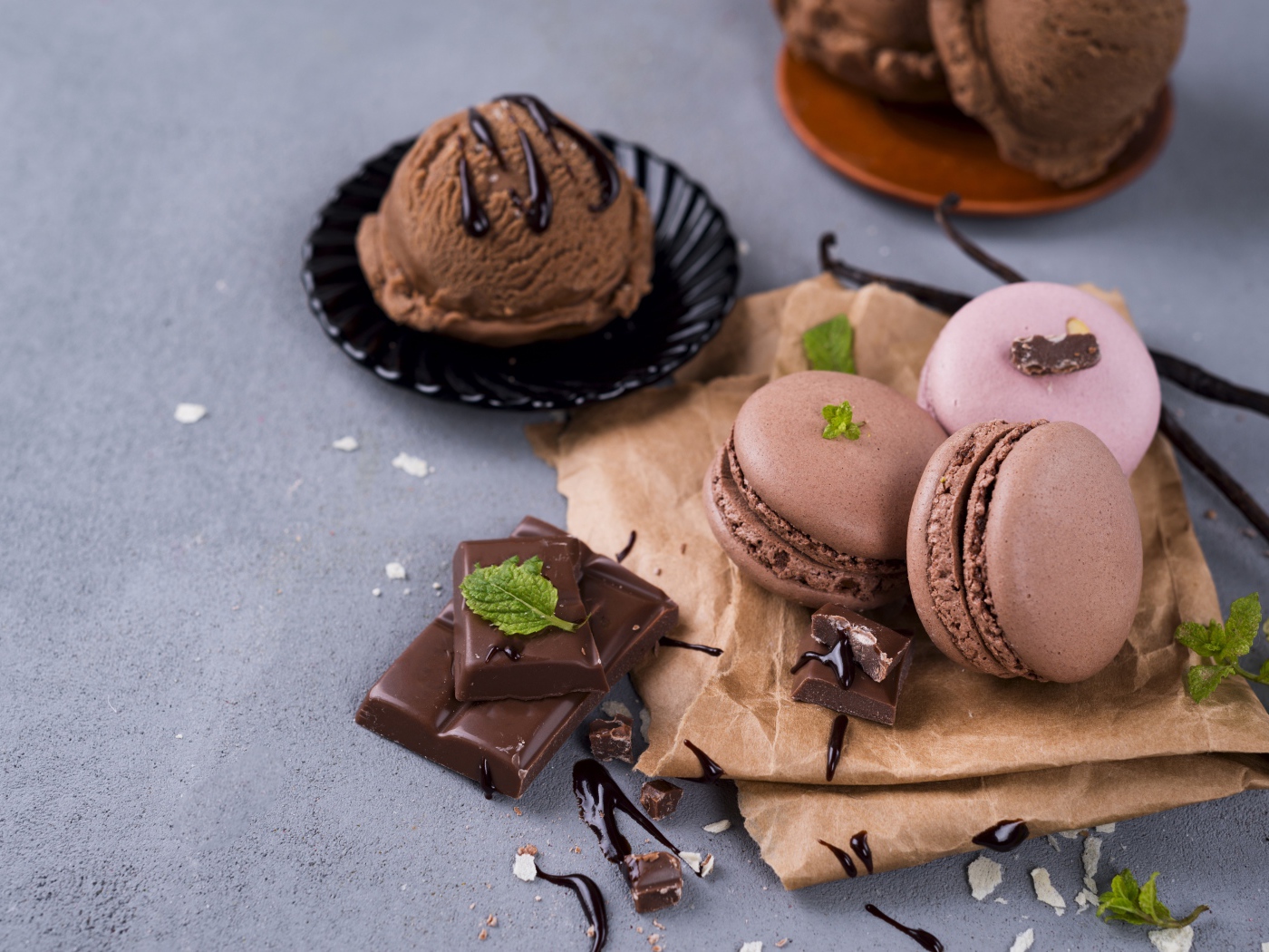 Печенье макарун на серой поверхности с мороженым и шоколадом