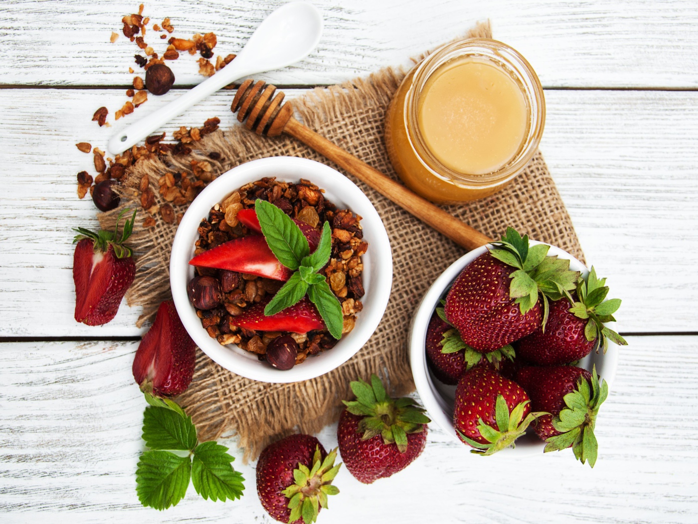 Орехи с ягодами клубники и медом на столе