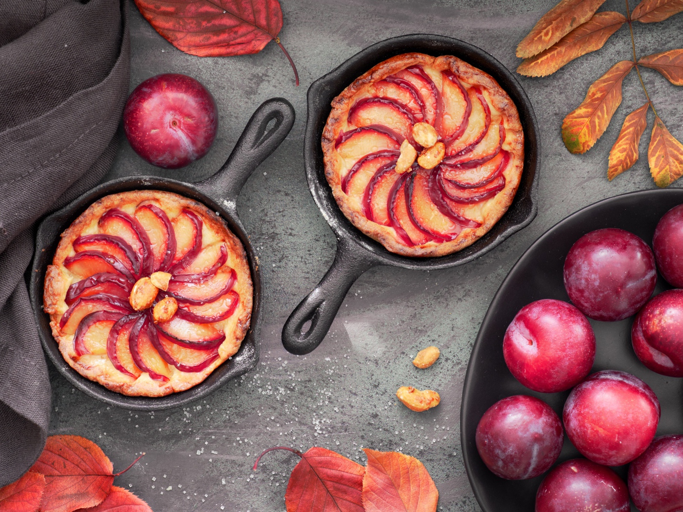 Пирог на столе с розовыми крупными сливами