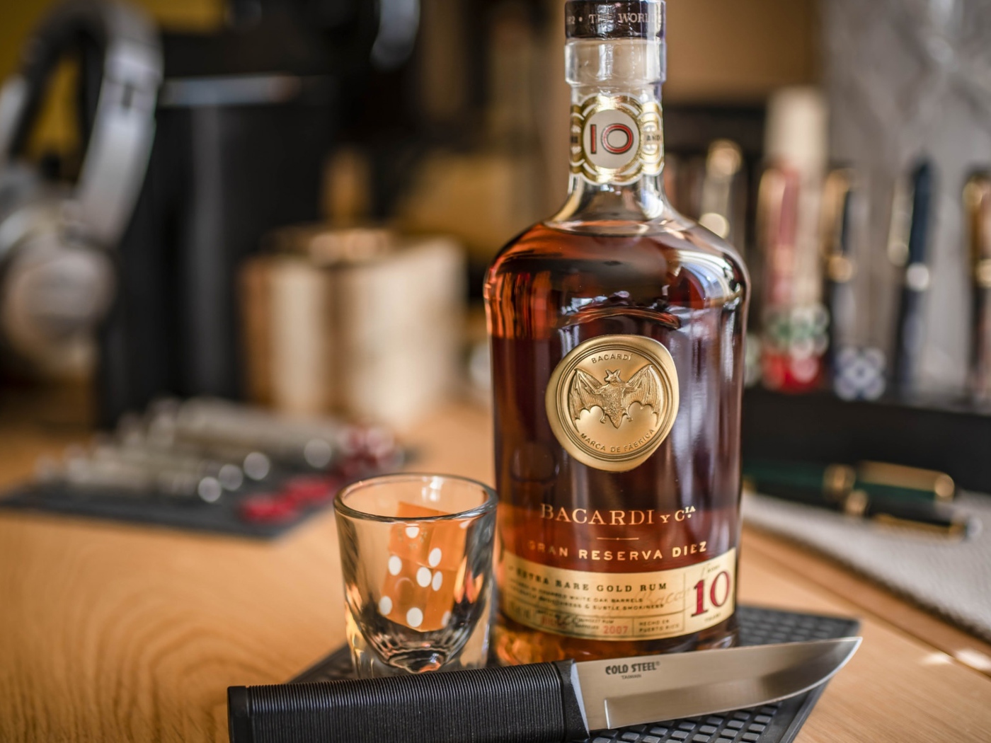 Бутылка виски на столе с рюмкой и ножом