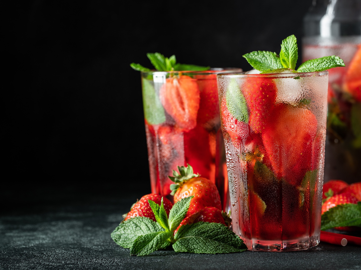 Холодный напиток в стакане на столе с клубникой и мятой