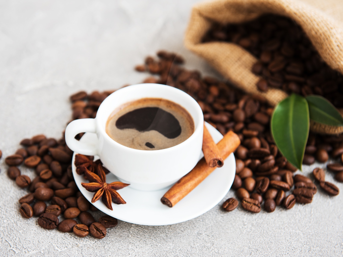Чашка кофе с корицей, бадьяном и кофейными зернами
