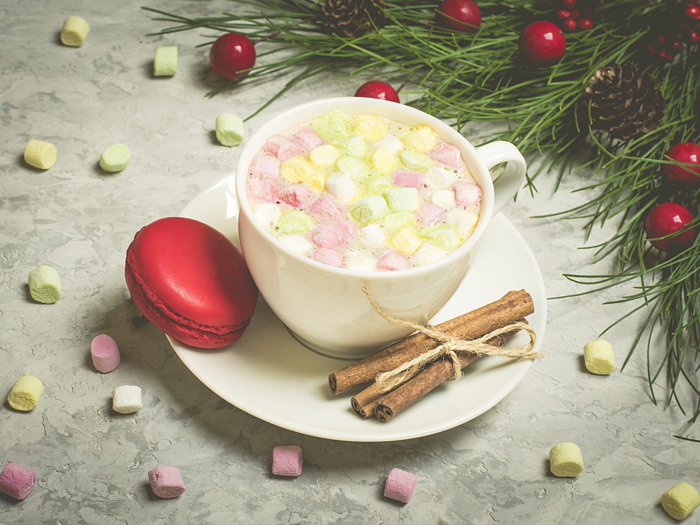 Напиток с маршмелоу на блюдце с макаруном и корицей