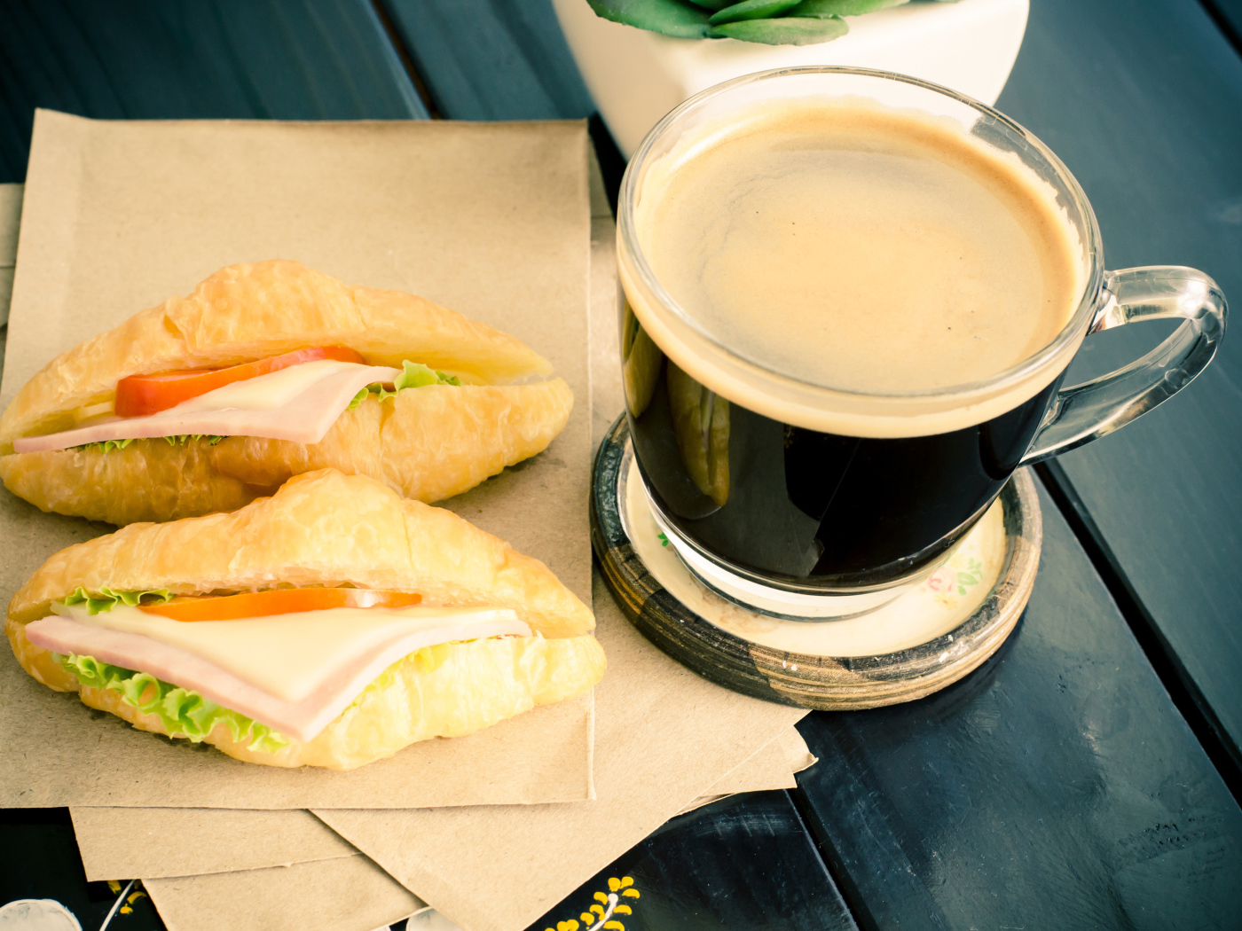 Стеклянная чашка кофе на столе с сэндвичами