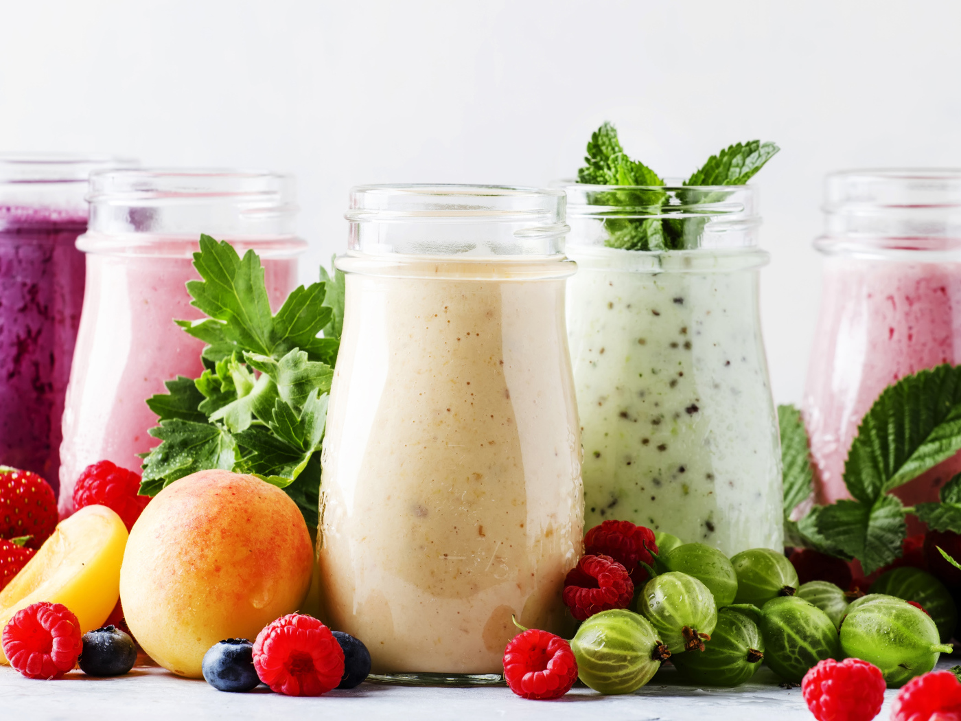Банки со смузи на столе с ягодами 