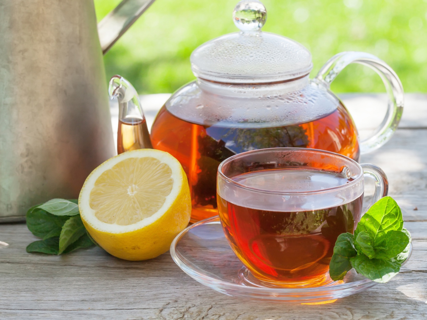 Чайник с чаем на столе с чашкой и половиной лимона