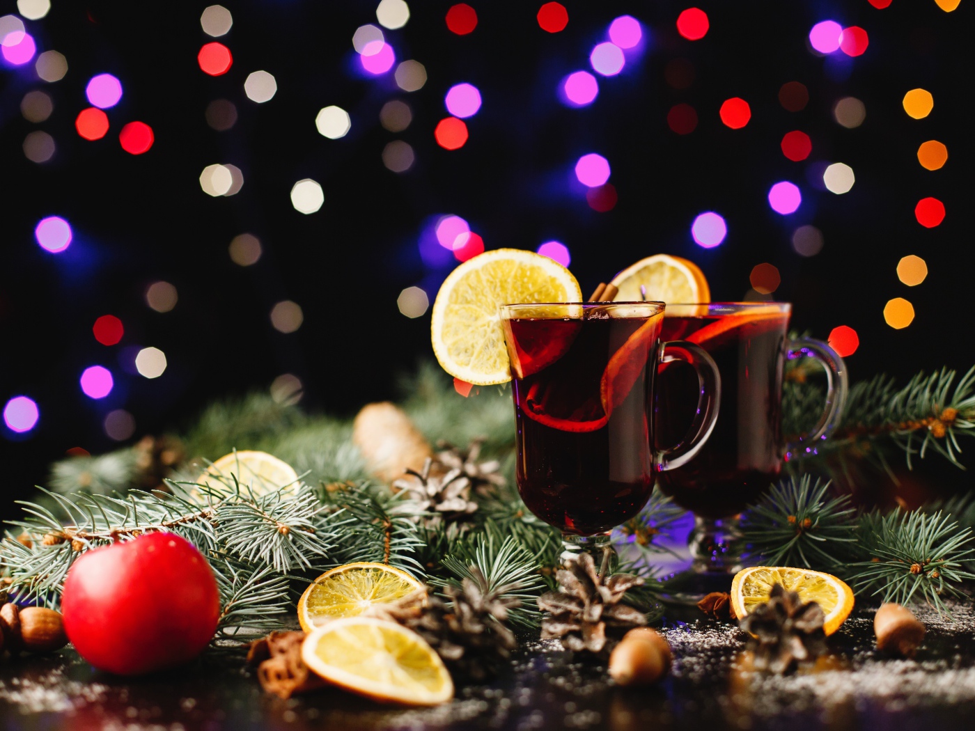 Два стакана глинтвейна на столе еловыми ветками 